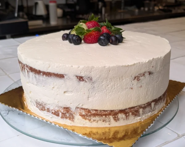 image of a vanilla cake with vanilla cream and berries on top